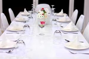 Chiang RaiAmarin Resort的一张摆放着白色盘子和酒杯的白色长桌 更多215张照片