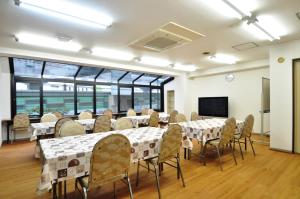 a conference room with tables and chairs and a tv at Hotel Koshien in Nishinomiya