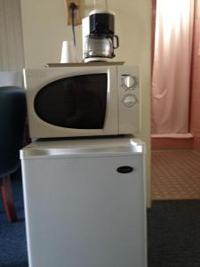 a microwave sitting on top of a refrigerator at Heidelberg Motel in Bridgeport