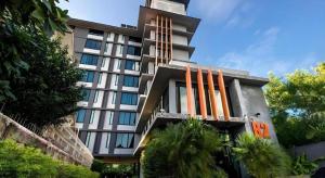 ein hohes Gebäude mit Palmen davor in der Unterkunft B2 Lampang City Boutique & Budget Hotel in Sathani Nakhon Lampang