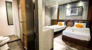 ein Bad mit 2 Betten und einem WC. in der Unterkunft B2 Lampang City Boutique & Budget Hotel in Sathani Nakhon Lampang + 99 Fotos