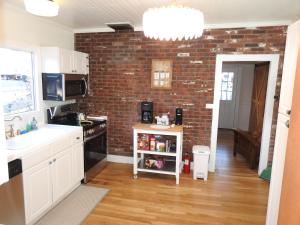 a kitchen with white cabinets and a brick wall at Miners Choice 3 Bedroom on Main St Bonus Rooms Sleeps up to 9 TV WIFI Piano in Julian +70 photos