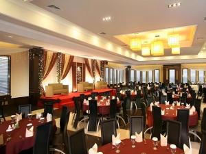 um salão de banquetes com mesas e cadeiras vermelhas em Orchardz Hotel Gajah Mada em Siantan