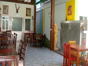 uma sala de jantar com mesas e cadeiras de madeira em Nayai Resort em Chalong