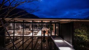 由布市にあるHotel MODAのガラス張りのファサードのある家と外に立っている人々