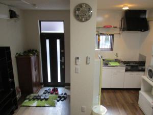 una cocina con puerta y zapatos en el suelo en Rainbow House, en Osaka