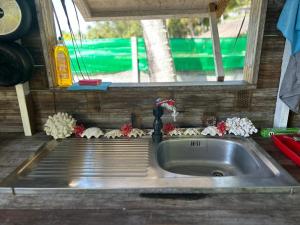 波拉波拉Bora Roots Camp的房车厨房里的水槽，旁边有一扇窗户 更多13张照片