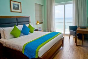 1 dormitorio con cama, escritorio y ventana en Ocean Edge Suites & Hotel Colombo, en Colombo