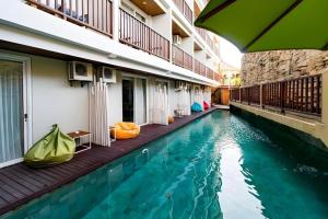 a swimming pool in the middle of a building at Hadi Poetra Hotel in Kuta