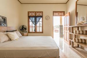 a bedroom with a large bed and a window at The Bali Boarding House in Uluwatu