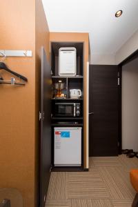 a kitchen with a refrigerator and a microwave at The CALM Hotel Tokyo in Tokyo
