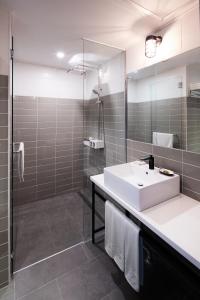 a bathroom with a sink and a shower and a mirror at Boutique Hotel BomBom in Gangneung