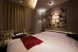 a hotel room with a large bed and a painting on the wall at The CALM Hotel Tokyo in Tokyo