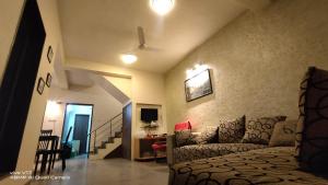 una sala de estar con una cama y un sofá en yash villa, en Lonavala