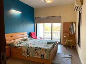 Un dormitorio con una cama y una pared azul. en yash villa, en Lonavala 9 fotos más
