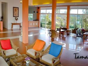 eine Lobby mit bunten Stühlen, Tischen und Fenstern in der Unterkunft Tamali Hotel in Ban Yuan Lae