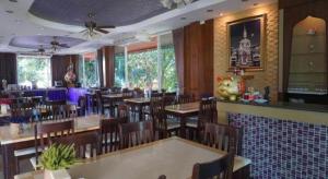 Ban Hua FaiSirimathani Hotel的餐厅里有桌椅的餐厅 更多74张照片