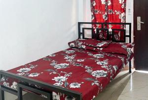 a bedroom with a bed with a red comforter at Hotel De Amado by RedDoorz in Dagupan +6 photos