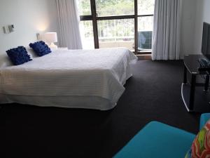 Un dormitorio con una cama grande con almohadas azules. en Kirribilli Apartments, en Brisbane