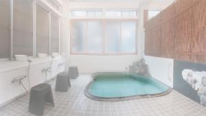 a bathroom with a tub in the middle of a room at Snow Monkey Lodge in Yamanouchi +60 photos