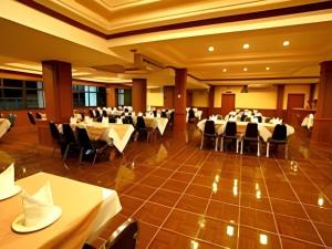 um salão de banquetes com mesas e cadeiras em uma sala em Phuthong Place em Phayao