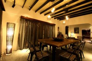 a dining room with a wooden table and chairs at The Pines Cottage in Melaka