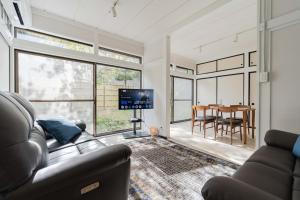 a living room with a couch and a dining room at Hakoshimizu Retreat - 10mins walk to Zenkoji in Nagano