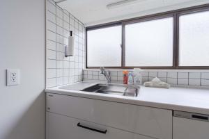 a white kitchen with a sink and two windows at Hakoshimizu Retreat - 10mins walk to Zenkoji in Nagano +88 photos