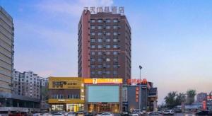 a tall red building in a city with cars at 7 Days Premium· Zhoushuizi Airport Wal-Mart in Dalian