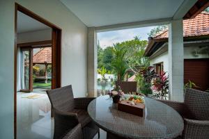 ein Esszimmer mit einem Tisch und Stühlen sowie eine Terrasse in der Unterkunft Villa Mahayoni in Bedahulu