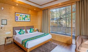 a bedroom with a bed and a large window at Treebo M R Villa in Manāli +36 photos