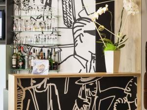 a bar with black and white graffiti on the wall at ibis Poitiers Centre in Poitiers