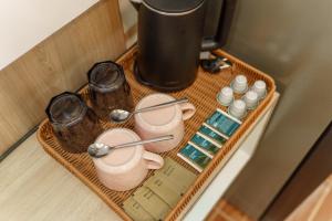 ein Tablett mit Tassen und Geschirr auf dem Tisch in der Unterkunft Three COCO Villa Aonang Krabi in Ao Nang Beach