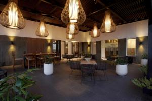una grande stanza con tavoli, sedie e luci di Aston Jambi Hotel & Conference Center a Jambi