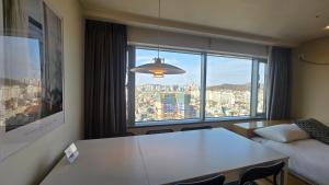 a hotel room with a table and a large window at Paradise Hongdae in Seoul