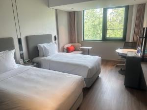a hotel room with two beds and a table at Holiday Inn Express Beijing Airport Zone by IHG in Beijing +90 photos