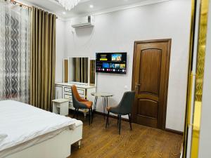 a hotel room with a bed and a table and chairs at Soro Hotel in Dushanbe