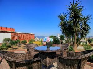 eine Terrasse mit einem Tisch mit Stühlen und Blumen in der Unterkunft GreenTree Inn Fuzhou Gulou District West Xierhuan Road Zuohai Park in Fuzhou