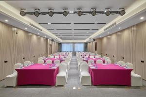 a banquet hall with pink tables and white chairs at Lavande Hotels Guangzhou Panyu Hanxi Changlong Dashi Subway Station in Guangzhou