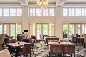 ein Restaurant mit Tischen und Stühlen und Fenstern in der Unterkunft Hyatt Hotel Canberra - A Park Hyatt Hotel in Canberra