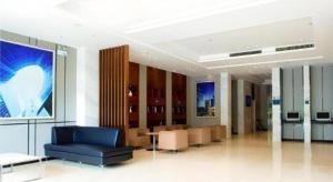 a lobby with a blue chair and tables in a building at City Comfort Inn Xianning South Station Wanda in Wenquanzhen