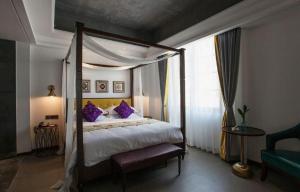 淳安Qiandao Lake CBS Beer Spa Hotel的一间卧室配有一张带紫色枕头的天蓬床 更多273张照片