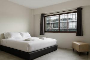 a bedroom with a large bed and a window at VS Beach Front in Jomtien Beach