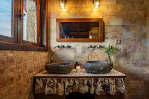 a bathroom with two sinks on a stone wall at Casona Asturiana Los Gamonales in Logrezana +78 photos