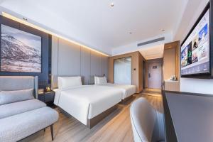 Una habitación de hotel con una cama y un televisor. en Royalton Hotel Xi'an Qujiang Conference Center Mixc, en Xi'an