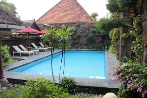 uma piscina em frente a um edifício em Prambanan Guesthouse em Yogyakarta
