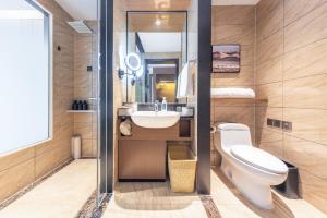 un baño con inodoro y lavabo en Royalton Hotel Xi'an Qujiang Conference Center Mixc, en Xi'an