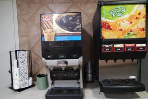 Super 8 by Wyndham Savannah في سافانا: ماكينة صنع القهوة وموزع المشروبات بجوار ماكينة صنع القهوة +22 صورة