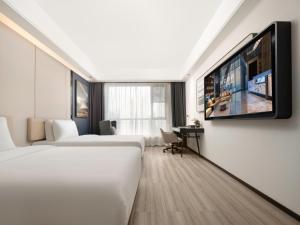 Una habitación de hotel con dos camas y un televisor de pantalla plana. en Royalton Hotel Xi'an Qujiang Conference Center Mixc, en Xi'an