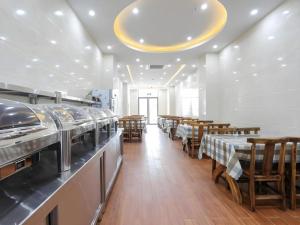 un ristorante con tavoli e sedie in una stanza di GreenTree Inn Jiaxin Puyuan Kaixuan Road a Puyuan